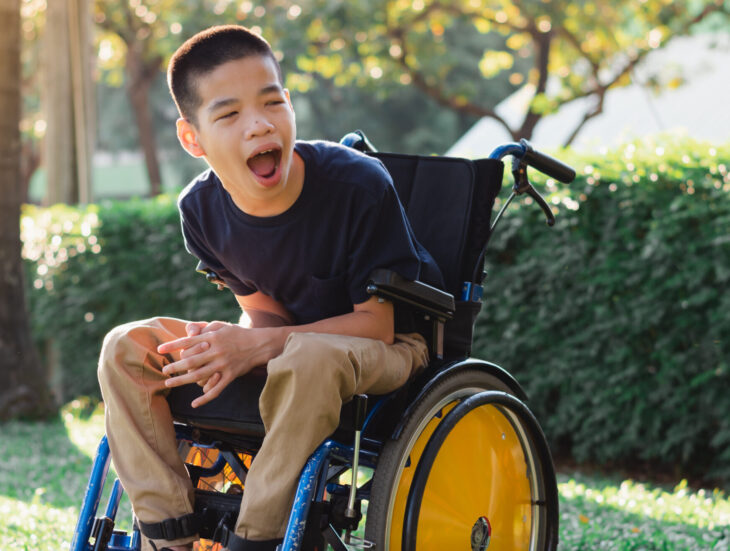 Disabled child on wheelchair is playing, learning and exercise in the outdoor city park like other people,Lifestyle of special child,Life in the education age of children,Happy disability kid concept.