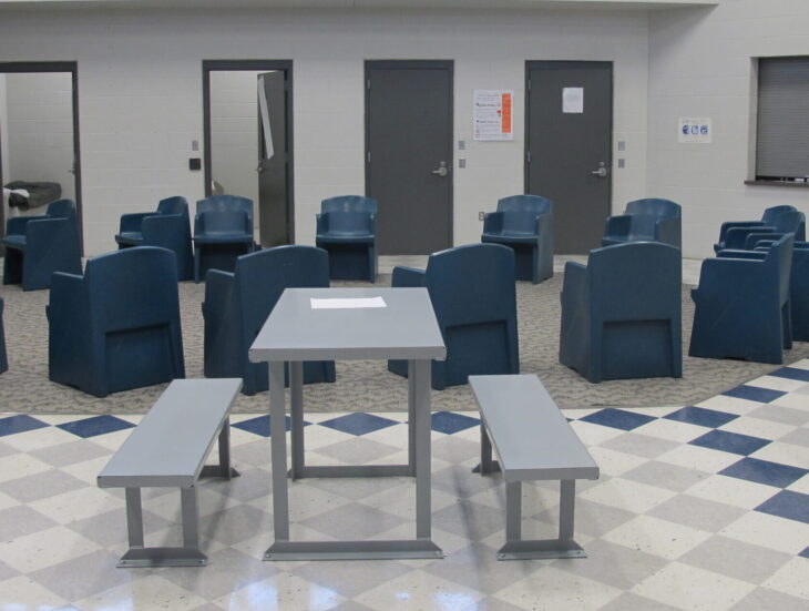 Room in MBAEA Juvenile Detention Center with circle of chairs and picnic style tables